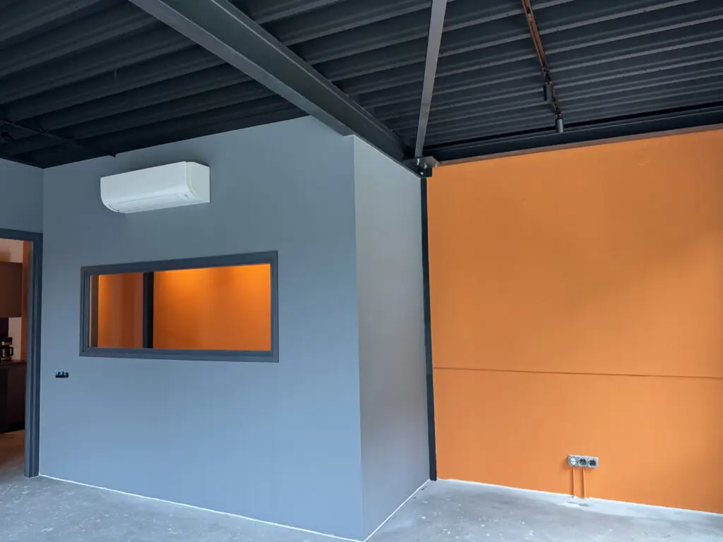 Moderne kamer met oranje muur en zwart gespoten plafond na latex spuiten.